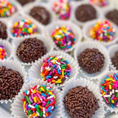 Brigadeiros com granulados coloridos e de chocolate em forminhas brancas