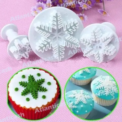 Moldes de gláciao floco de neve em plástico branco e cupcakes decorados