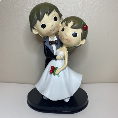 Estatueta de noivos em cerâmica ou resina, com noivo de fato preto e noiva de vestido branco com flores vermelhas