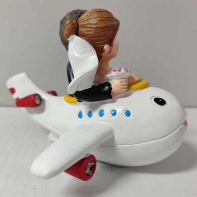Figuras de casal de noivos em avião de resina branco com detalhes vermelhos e azuis