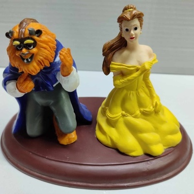 Figuras de plastico da Bela e a Fera numa base oval castanha