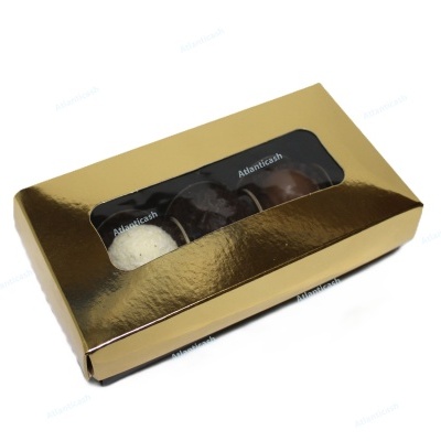 Caixa dourada com três bombons visíveis e etiquetas 'Atlanticash'.