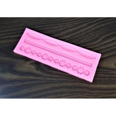 Molde de silicone rosa com padrões em relevo sobre madeira escura