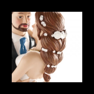 Figuras de bolo de noiva e noivo vestidas formalmente com detalhes florais no cabelo da noiva