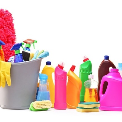 Produtos de limpeza coloridos organizados junto a um balde cinzento com luvas amarelas