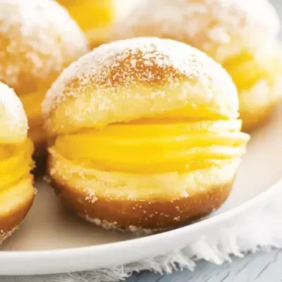 Bola de berlim com recheio amarelo cremoso e açúcar polvilhado