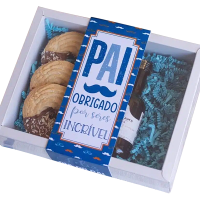 Caixa de presente com biscoitos e uma pequena garrafa, etiqueta azul com texto para pai