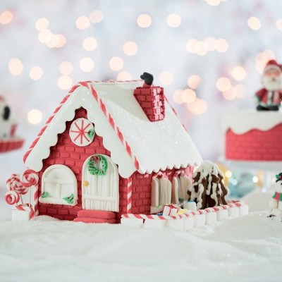 Casa de gengibre decorativa de Natal com detalhes vermelhos e brancos