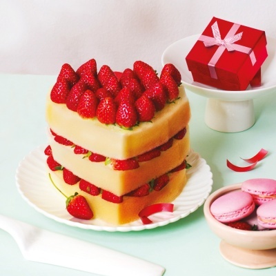 bolo de coração com morangos e pão, caixa vermelha com fita e macarons cor de rosa