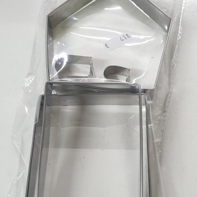 Conjunto de cortadores de bolachas metálicos em forma de casa, embalagem com etiqueta e preço visível.