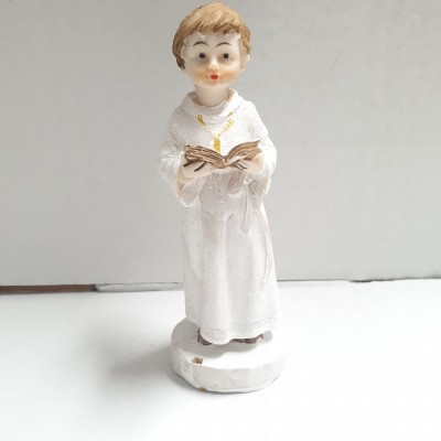 Figura decorativa de criança em túnica branca a segurar livro.