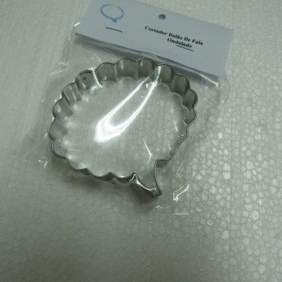 Cortador de bolos de vidro ondulado metal prateado na embalagem sobre superfície branca