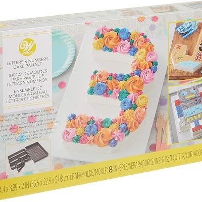 Conjunto de moldes para bolo em forma de números e letras da Wilton numa caixa branca com imagens do produto decorado.