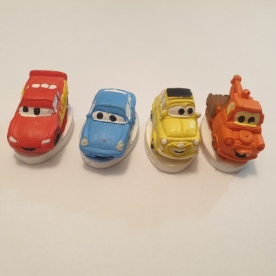 Miniaturas coloridas de quatro carros com olhos no para-brisas