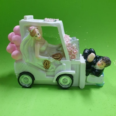 Noivos em resina num carrinho branco com balões cor-de-rosa
