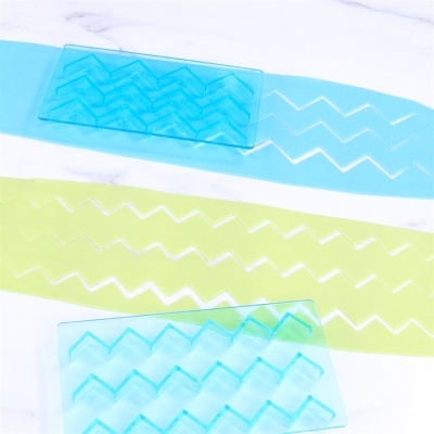 Moldes de silicone azuis e faixas verdes com padrão zig-zag sobre superfície branca