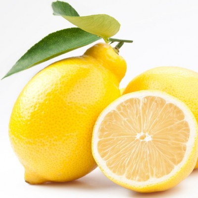 Limões amarelos com folhas verdes num fundo branco