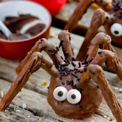 Aranha de chocolate com olhos de açúcar e granulados sobre superfície de madeira