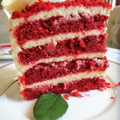 Fatia de bolo de veludo vermelho com creme branco entre camadas