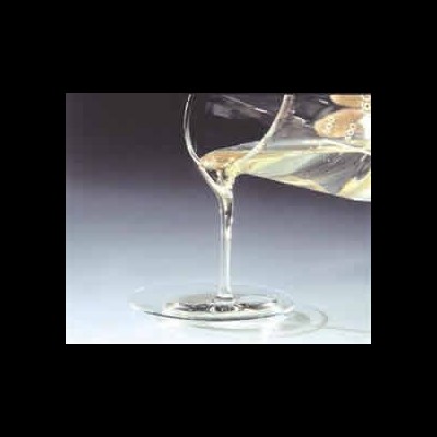 Taça de vidro transparente com líquido claro sendo derramado