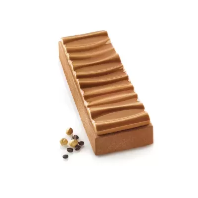 Barra de chocolate castanha clara com textura ondulada e pequenos grãos coloridos ao lado