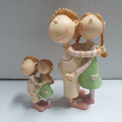 Duas figuras decorativas de casal a abraçar, com roupas coloridas e expressões sorridentes