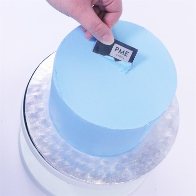 Bolo redondo azul com etiqueta PME CAKES na parte superior