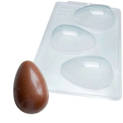 Forma plástica transparente com cavidades em forma de ovo e ovo de chocolate castanho