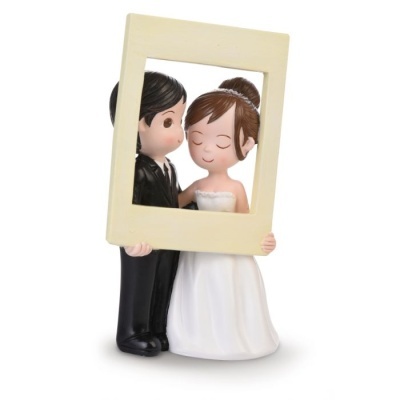 Estatueta de casal de noivos com quadro bege numa pose carinhosa