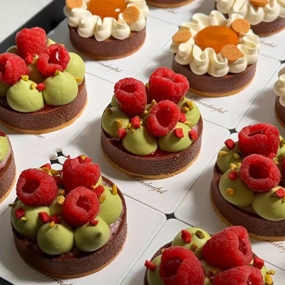Tartes com base de chocolate, creme verde, framboesas frescas e decoração colorida