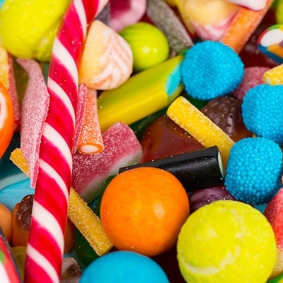 Doces coloridos variados incluindo pirulitos e balas redondas