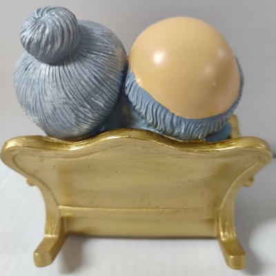 Estatueta de casal idoso sentado num banco dourado vista traseira