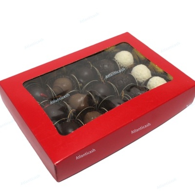 Caixa vermelha com tampa transparente cheia de trufas de chocolate variadas