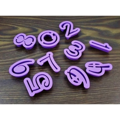 Conjunto de moldes de números em plástico rosa sobre mesa de madeira