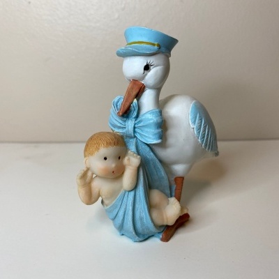 Figurinha de cegonha com bebé em manta azul