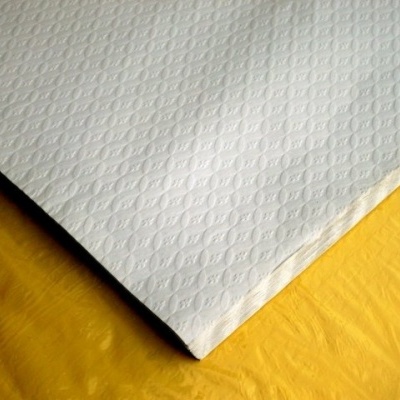 Toalha branca texturizada sobre fundo amarelo.