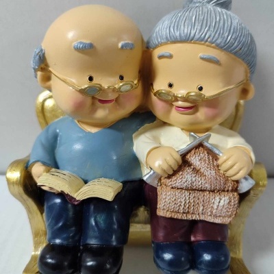 Figura decorativa de casal idoso a ler e tricotar