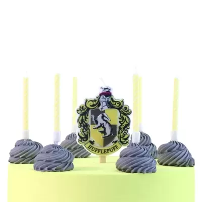 bolo verde claro com creme cinza, velas amarelas e emblema Hufflepuff