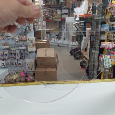 Mão a segurar círculo transparente num ambiente de loja ou armazém