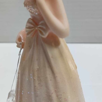 Figura feminina em vestido longo creme com laço e tiara prateada