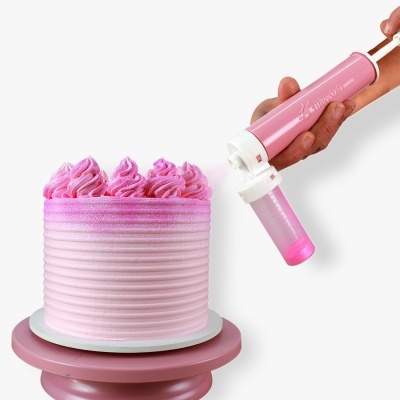 Bolo rosa com decoração creme e aplicador de creme nas mãos