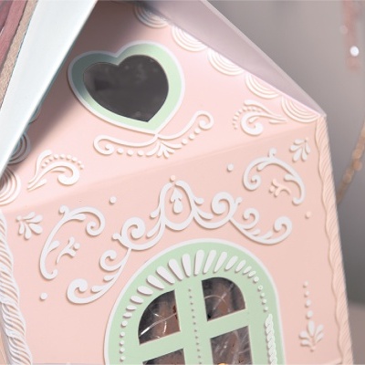 Embalagem em forma de casa cor-de-rosa decorada com detalhes em relevo e janela verde