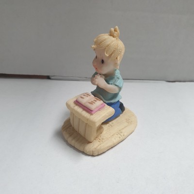 Miniatura de menino loiro ajoelhado diante de púlpito com livro