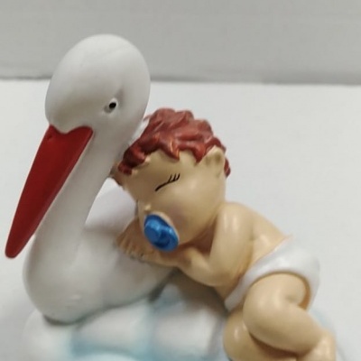 Figura decorativa de bebé a dormir sobre cegonha branca numa nuvem azul e branca