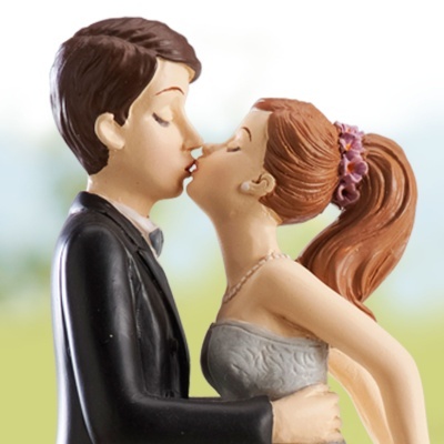 Estatueta de casal a beijar, homem com fato preto e mulher com vestido cinzento e cabelo apanhado