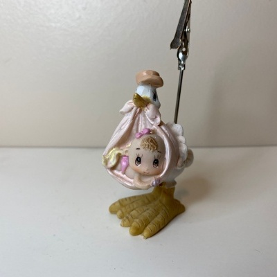 Figura de bebé dentro de ovo com pata amarela e suporte metálico