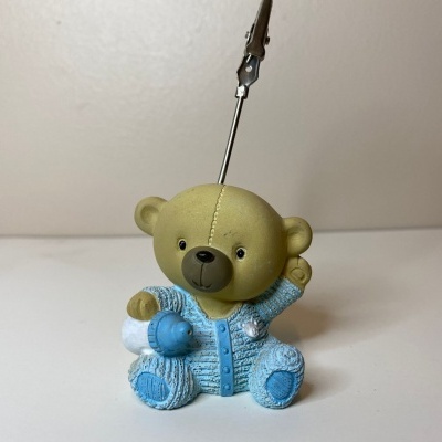 Chaveiro ursinho azul claro e branco sobre superfície branca