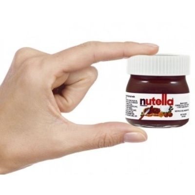 Frasco pequeno de Nutella segurado por mão com fundo branco.