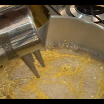 Panela metálica a cozinhar esparguete no fogão a gás