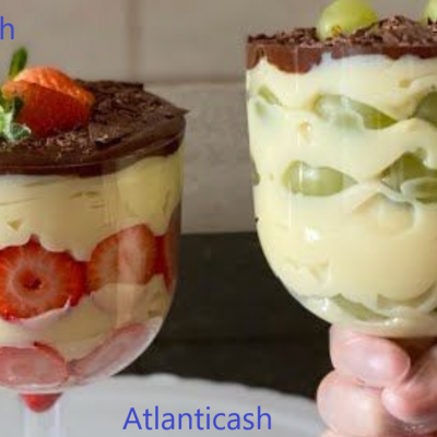 Duas taças com sobremesas cremosas com frutas e chocolate ralado.